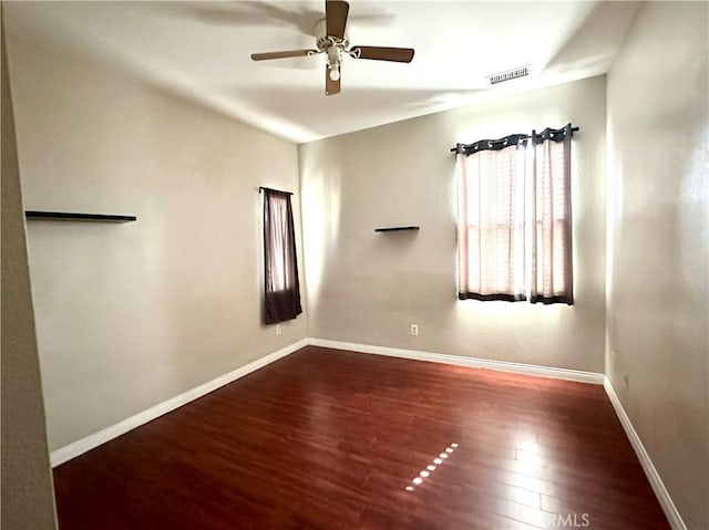 spare room with ceiling fan and dark hardwood / wood-style flooring