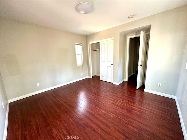 unfurnished bedroom with a closet and dark wood-type flooring