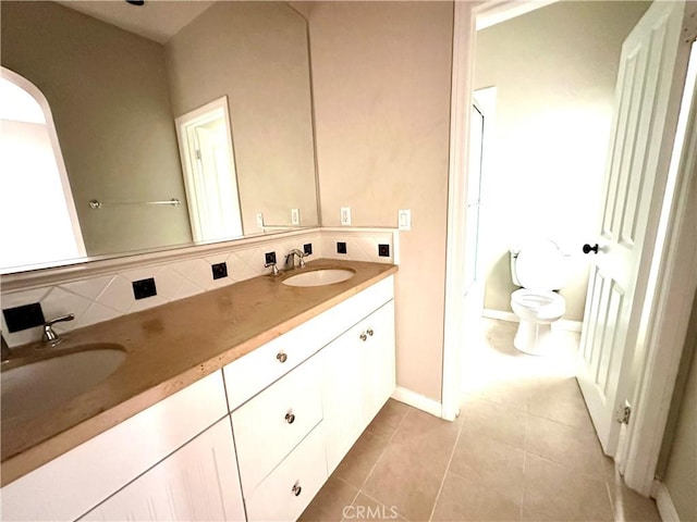 bathroom with vanity, backsplash, tile patterned floors, and toilet