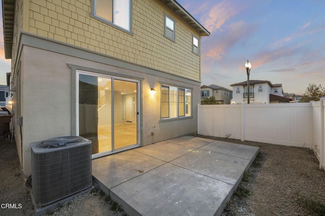 patio terrace at dusk with central air condition unit