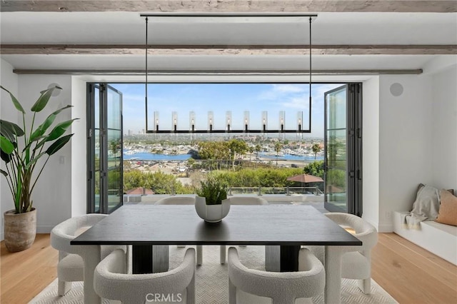 dining area featuring beam ceiling and light wood-type flooring