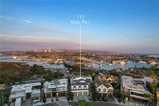 aerial view at dusk featuring a water view