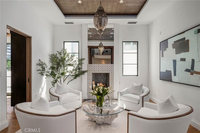 living area featuring a tray ceiling, hardwood / wood-style floors, and wooden ceiling