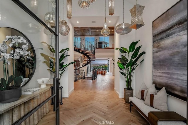 corridor with a towering ceiling and light parquet flooring