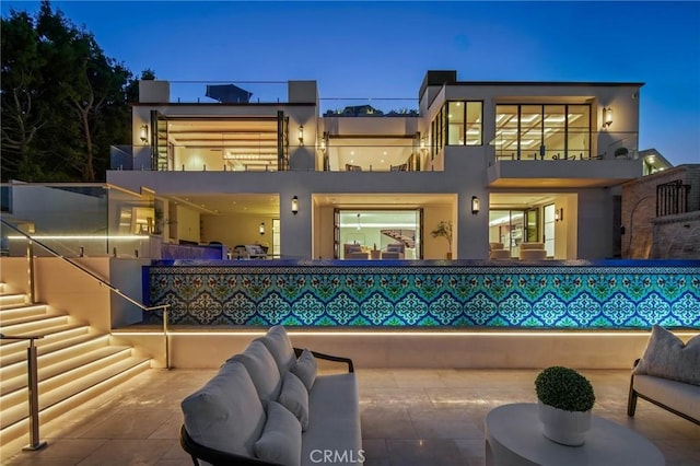 back of house with an outdoor hangout area, a balcony, and a patio area