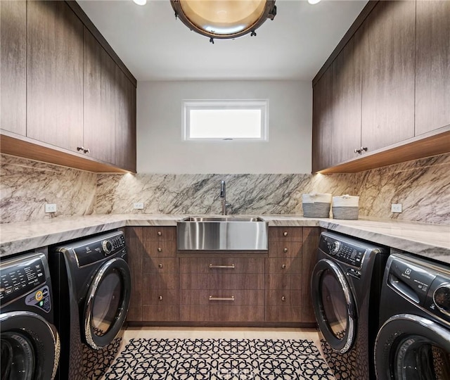 laundry room featuring washer and clothes dryer, light tile patterned floors, cabinets, and sink