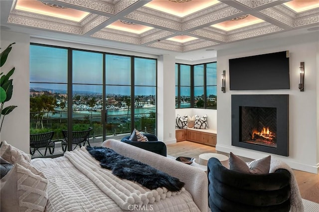 bedroom featuring beam ceiling, crown molding, light hardwood / wood-style flooring, and coffered ceiling