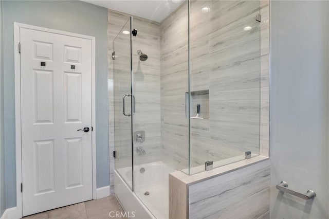 bathroom with tile patterned flooring and bath / shower combo with glass door