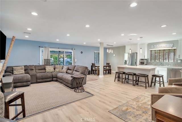 living room with light hardwood / wood-style flooring and sink