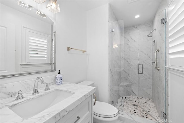 bathroom featuring vanity, an enclosed shower, and toilet