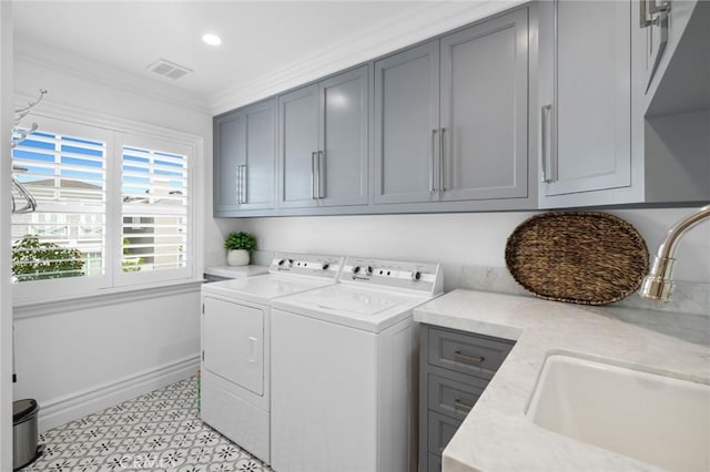 laundry area with washer and clothes dryer, cabinets, ornamental molding, and sink