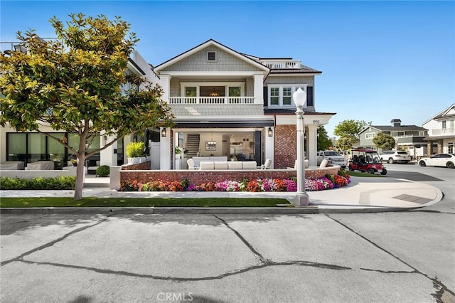 view of front of house with an outdoor living space and a balcony