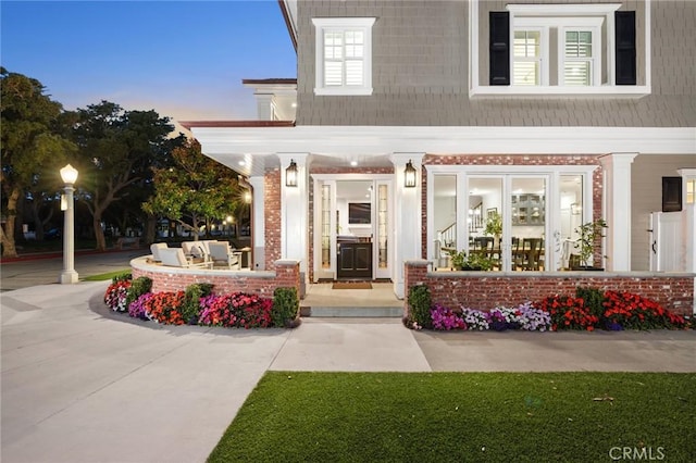 exterior entry at dusk featuring an outdoor living space