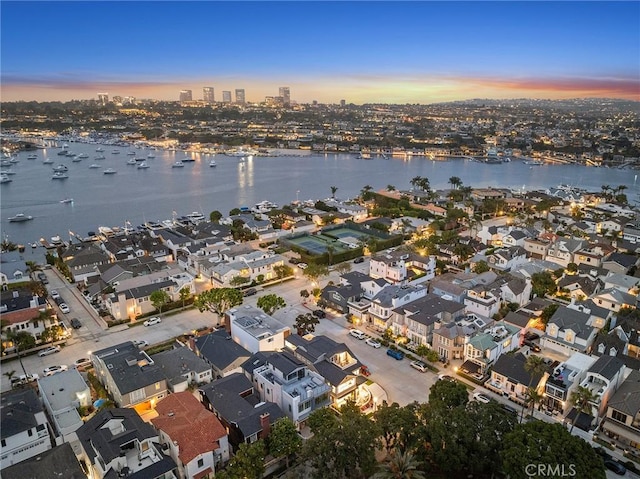 aerial view at dusk featuring a water view