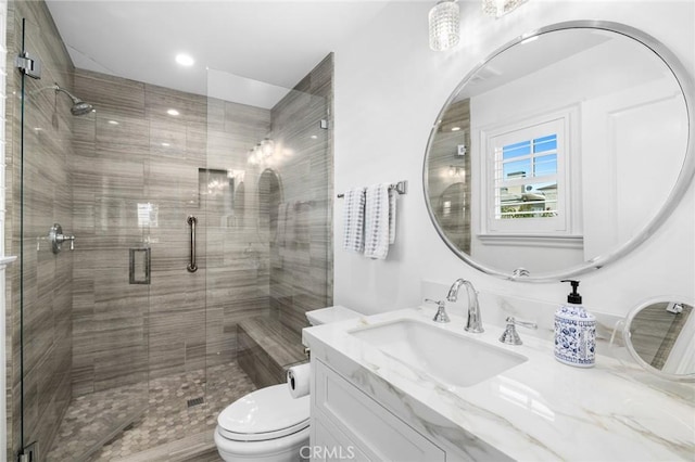 bathroom featuring vanity, toilet, and an enclosed shower