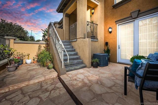 patio terrace at dusk with outdoor lounge area and central AC unit