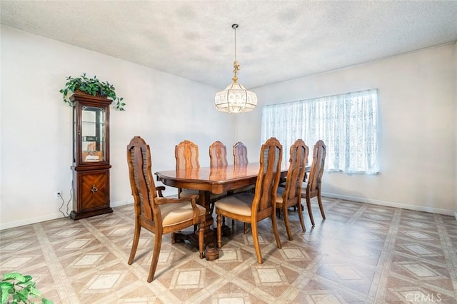 dining room featuring an inviting chandelier, a textured ceiling, and parquet flooring