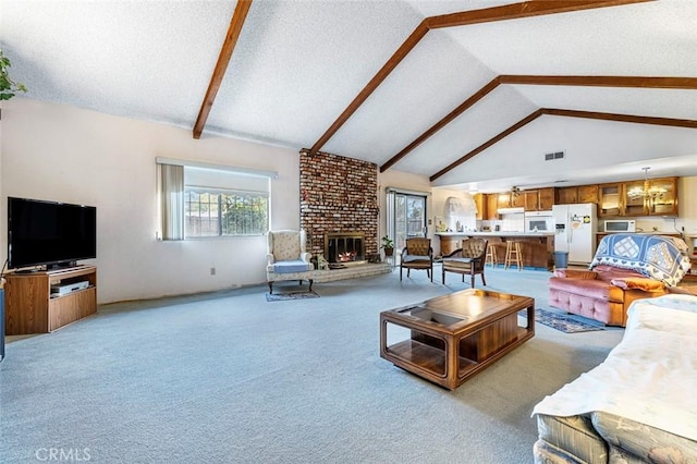 living room with carpet floors, a fireplace, high vaulted ceiling, and a chandelier