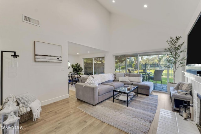 living room with light wood-type flooring and a high ceiling