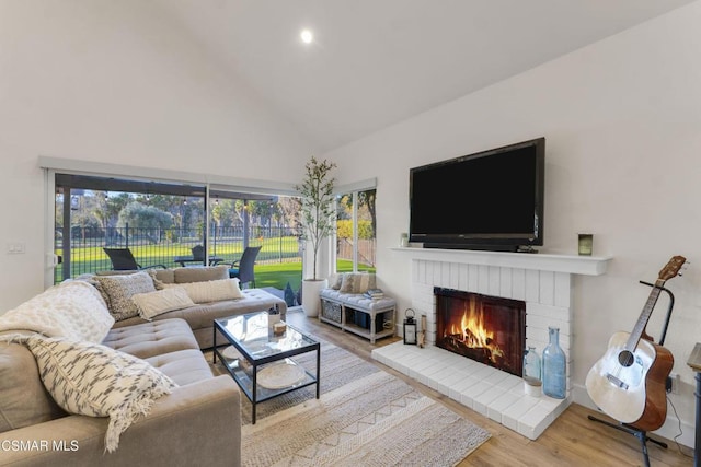 living room featuring hardwood / wood-style flooring, a fireplace, and lofted ceiling