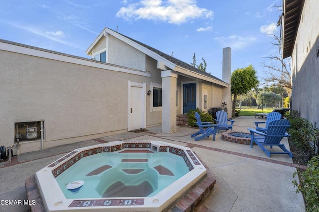 view of pool featuring a fire pit, an in ground hot tub, and a patio