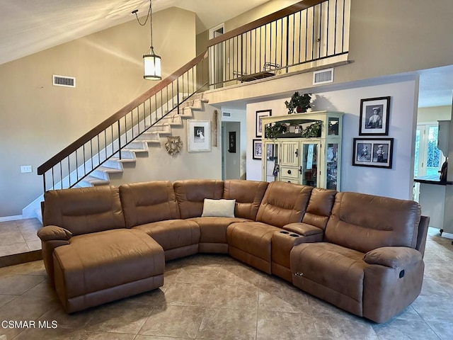 living room featuring tile patterned floors and high vaulted ceiling