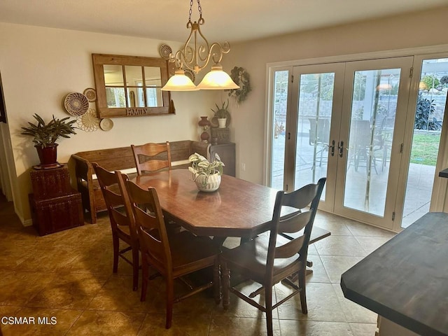 dining space featuring a chandelier, french doors, and tile patterned flooring