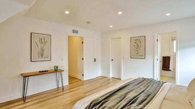 bedroom featuring ensuite bathroom and light hardwood / wood-style floors