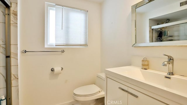 bathroom featuring vanity, toilet, and an enclosed shower