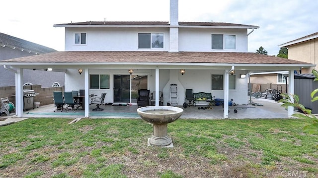 rear view of property with a lawn and a patio