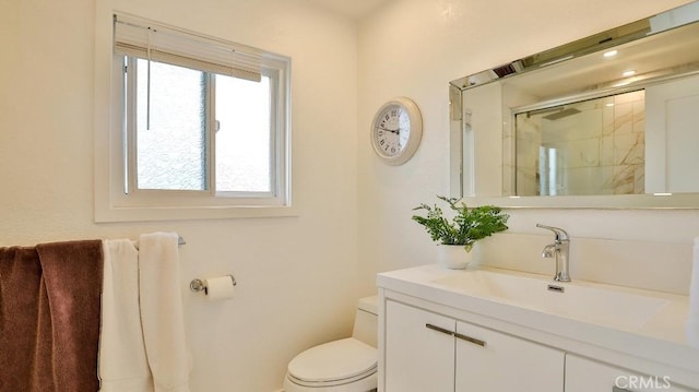 bathroom featuring vanity, toilet, and walk in shower