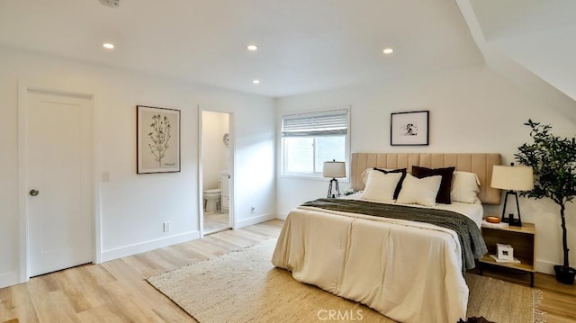 bedroom with light wood-type flooring and connected bathroom