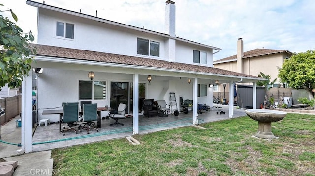 rear view of house with a patio area and a yard