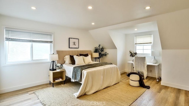 bedroom featuring light wood-type flooring and vaulted ceiling