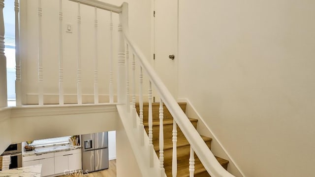 staircase featuring plenty of natural light and wood-type flooring