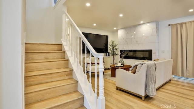 living room with hardwood / wood-style floors and a tiled fireplace