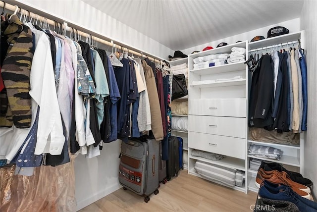 walk in closet with light hardwood / wood-style floors