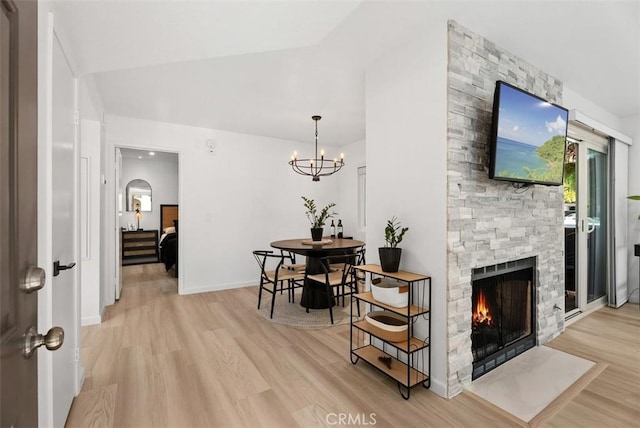 interior space with a fireplace, light hardwood / wood-style flooring, and an inviting chandelier