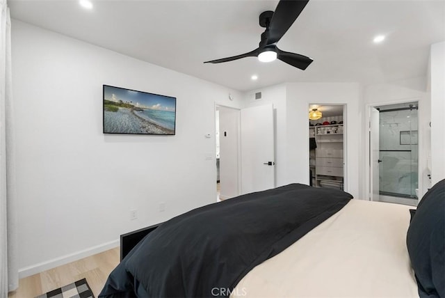 bedroom featuring ceiling fan, light hardwood / wood-style floors, a spacious closet, and a closet