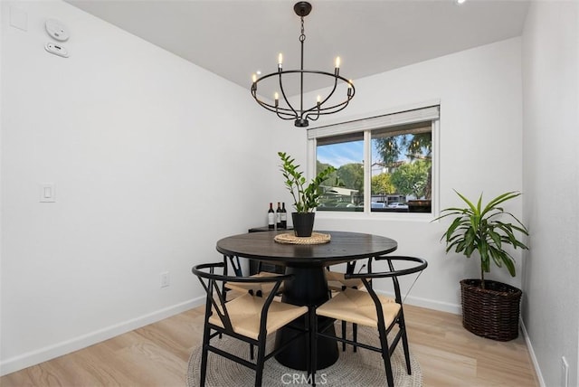 dining area with an inviting chandelier and light hardwood / wood-style flooring