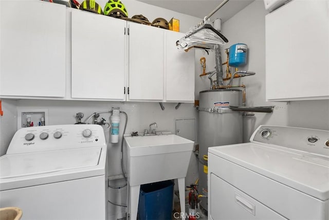 laundry room featuring secured water heater, cabinets, sink, and washing machine and clothes dryer