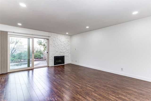 unfurnished living room featuring a high end fireplace and dark wood-type flooring