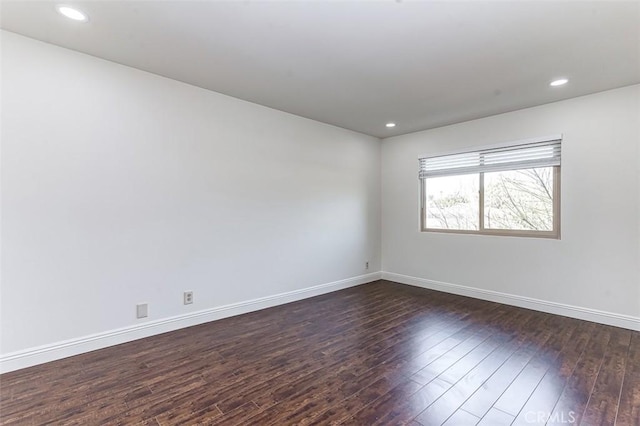 empty room with dark hardwood / wood-style flooring