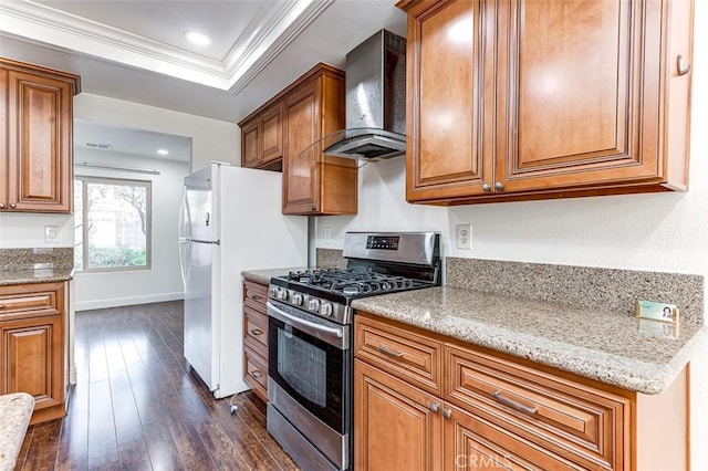 kitchen with stainless steel gas range, wall chimney exhaust hood, dark wood-type flooring, light stone counters, and crown molding