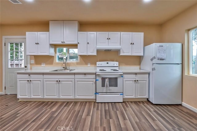 kitchen with light wood-type flooring, white appliances, sink, white cabinetry, and plenty of natural light