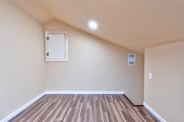 additional living space featuring hardwood / wood-style floors and vaulted ceiling