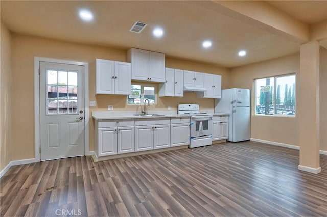 kitchen with sink, white cabinets, white appliances, and hardwood / wood-style flooring