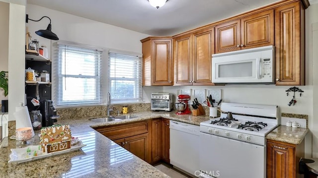 kitchen with light stone countertops, sink, plenty of natural light, and white appliances