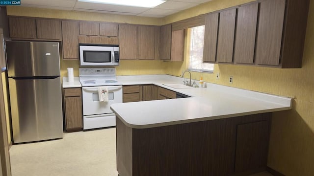 kitchen featuring kitchen peninsula, a paneled ceiling, stainless steel appliances, and sink