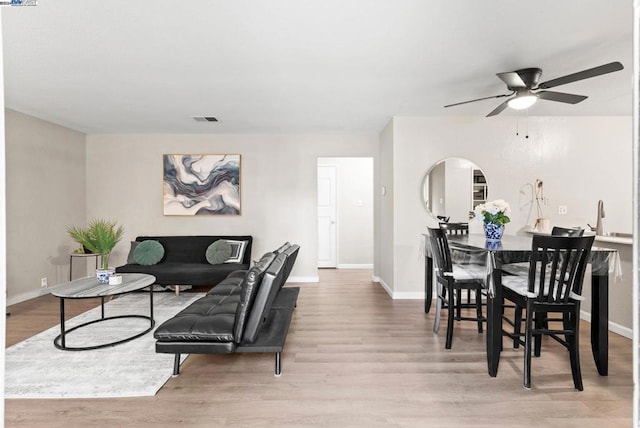 living room with ceiling fan and light wood-type flooring